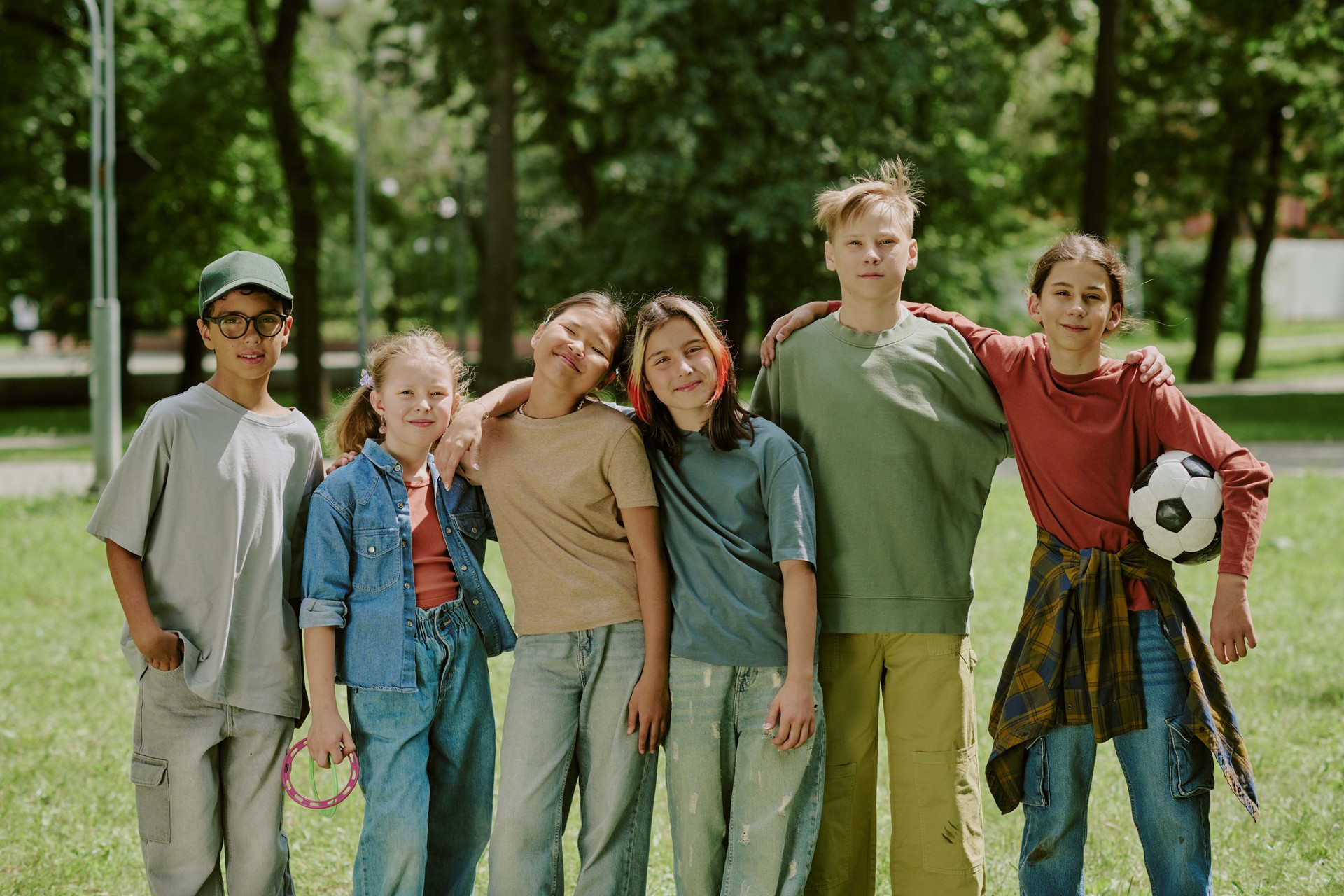 Group of Multiethnic School Children Standing Together Smiling in Park Outdoors
