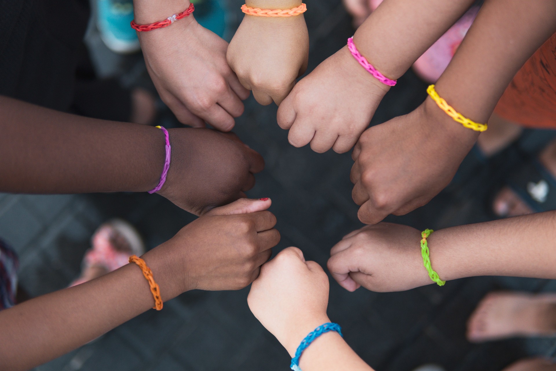 Multiethnic children hands together with rainbow bracelets