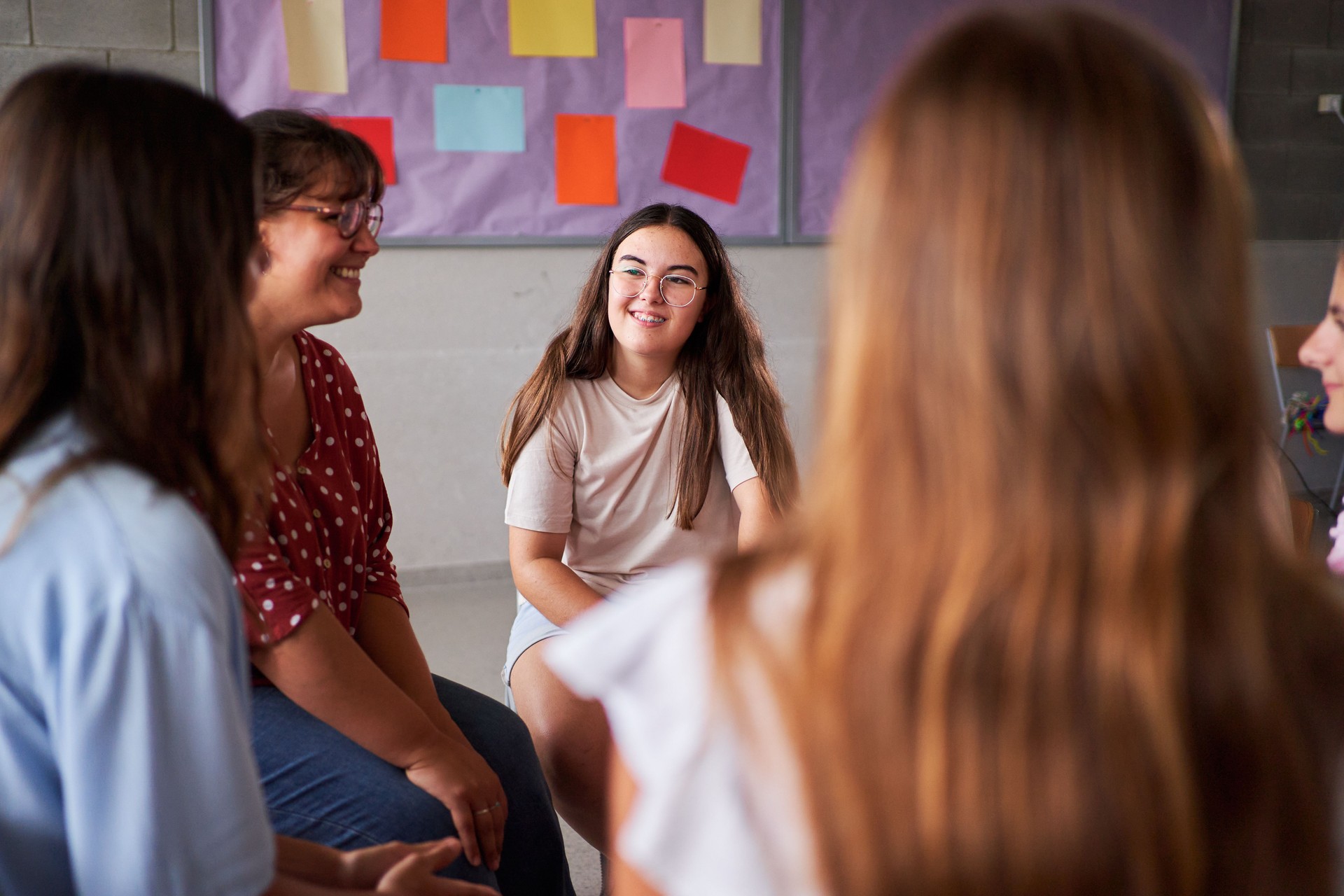 Teenage student girls sharing and talking at support group meeting.