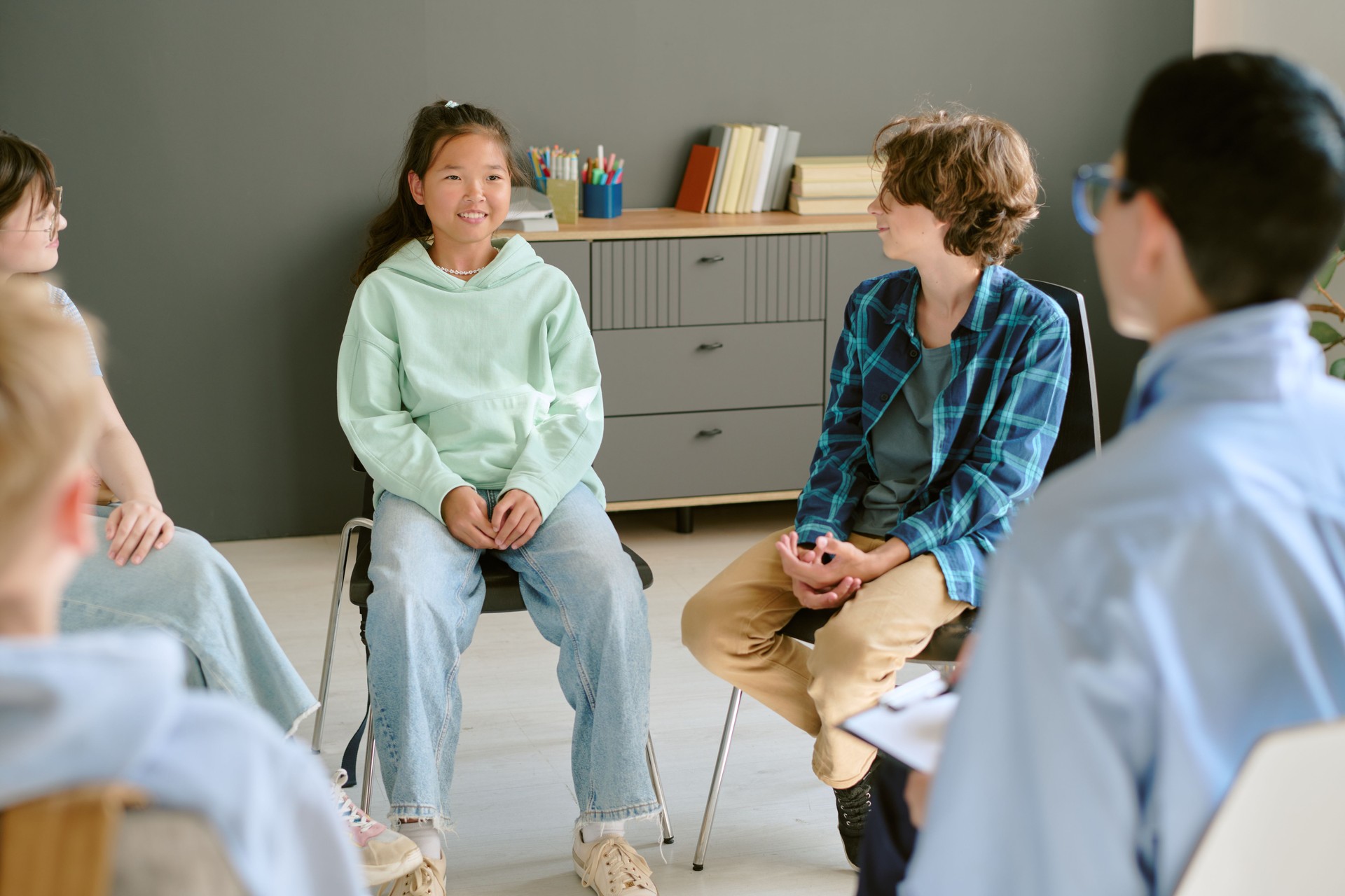 Multiethnic Teenagers Sitting in Group Therapy Session and Engaging in Discussion